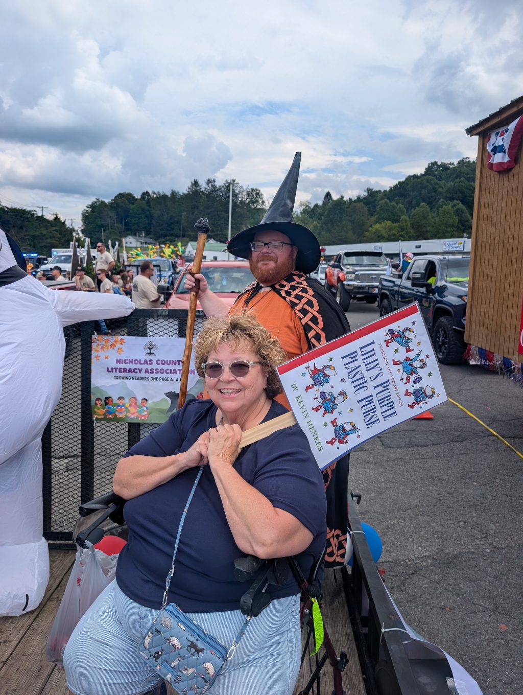 NCLA Secretary Adam Rose dressed as a wizard as NCLA Treasurer Teresa Brown waves a sign.